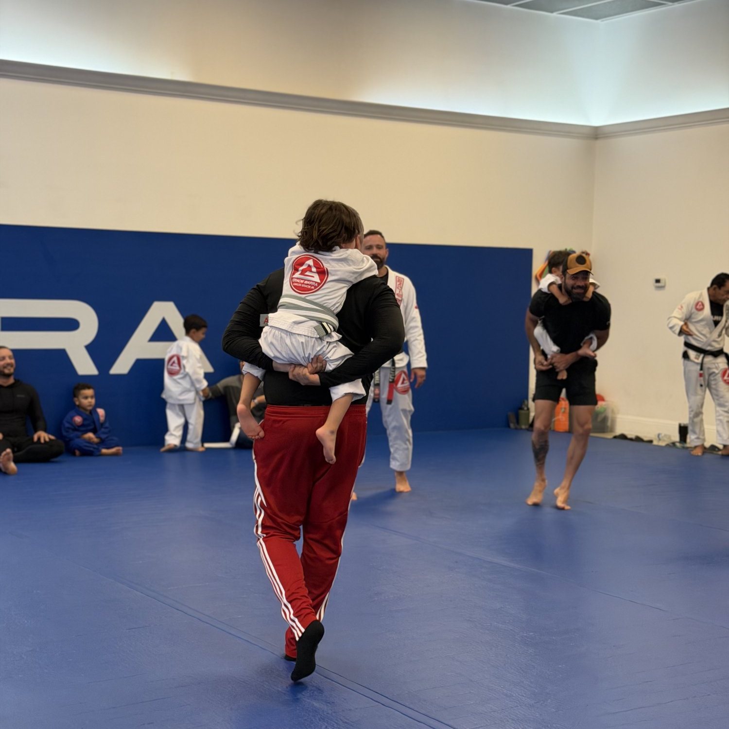 Kids and adults training Brazilian Jiu-Jitsu at a Gracie Barra academy